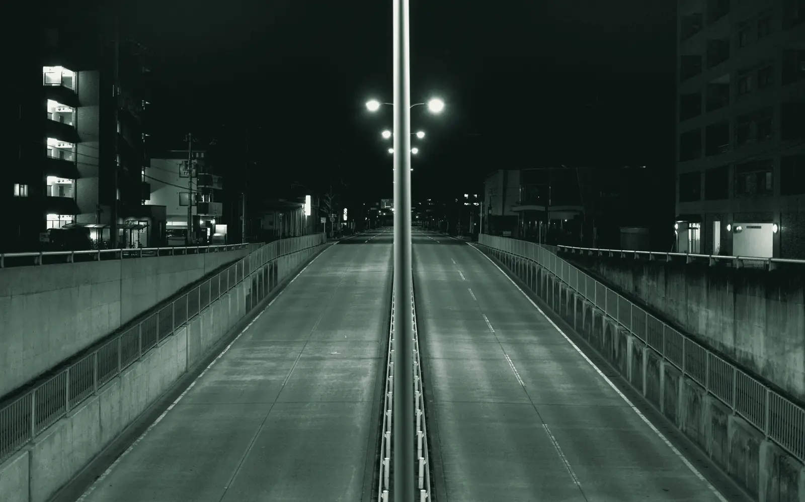 An empty, lit roadway ramp at night